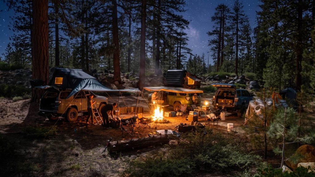 Campsite with tents and campfire under a starry night sky in the pines near Shaver Lake, Sierra National Forest